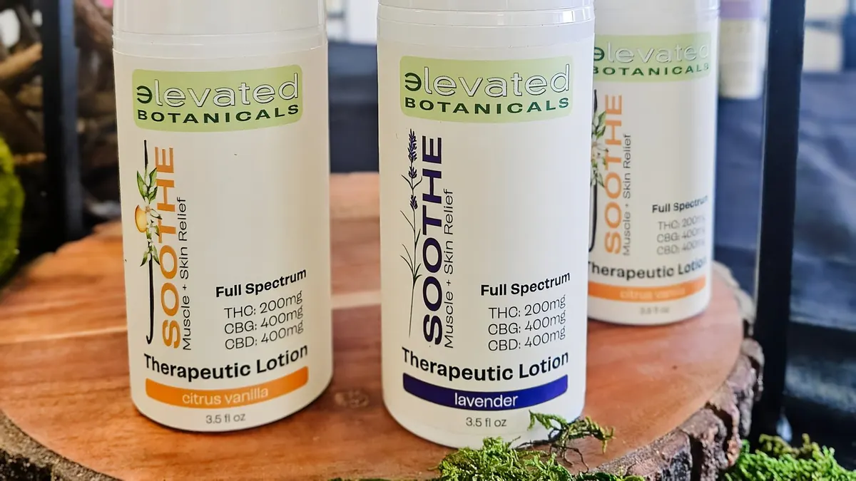 Elevated Botanicals Soothe lotion bottles in citrus vanilla and lavender on a wooden display